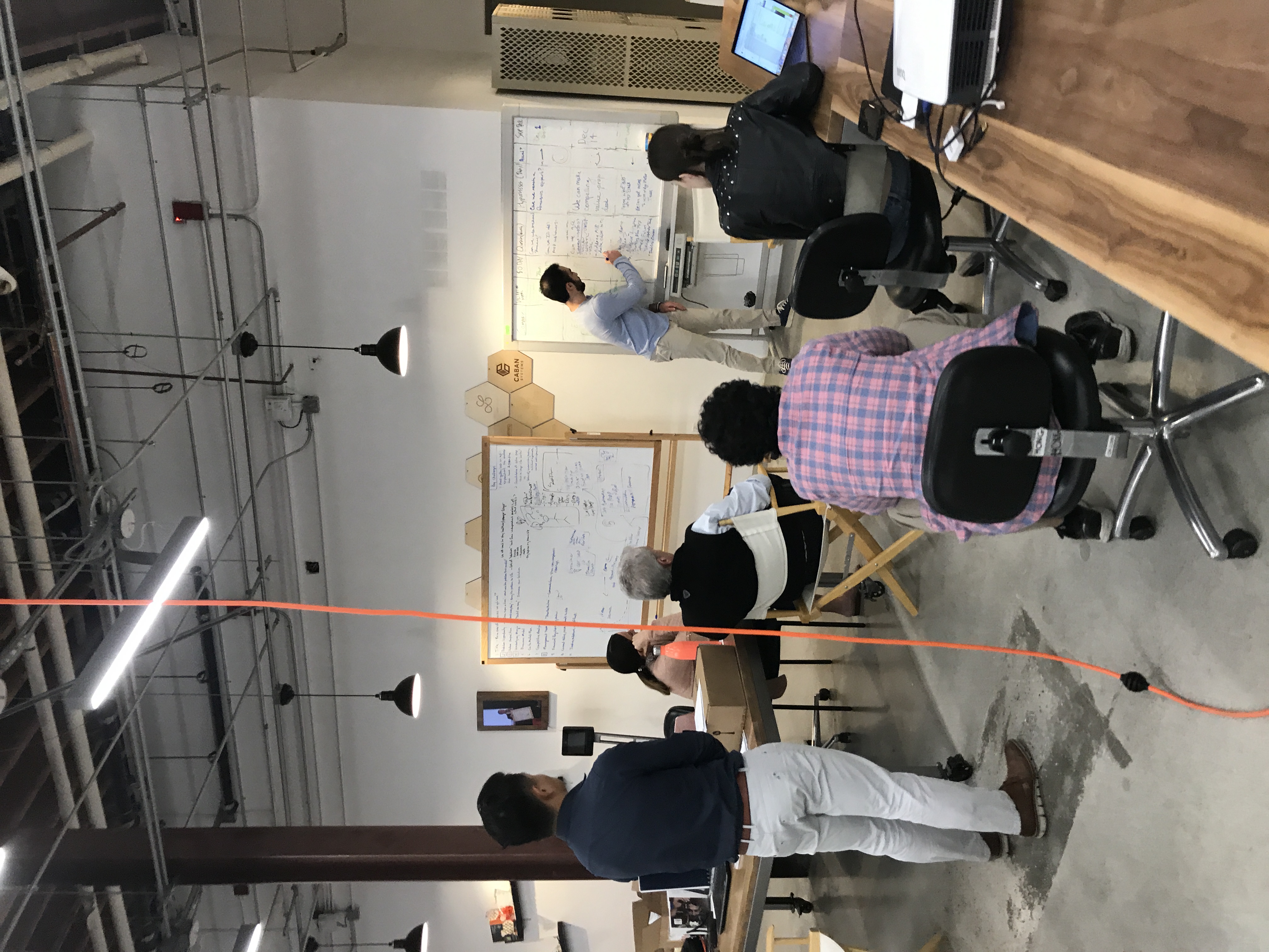 Startup team collaborating around whiteboards in a workshop space.