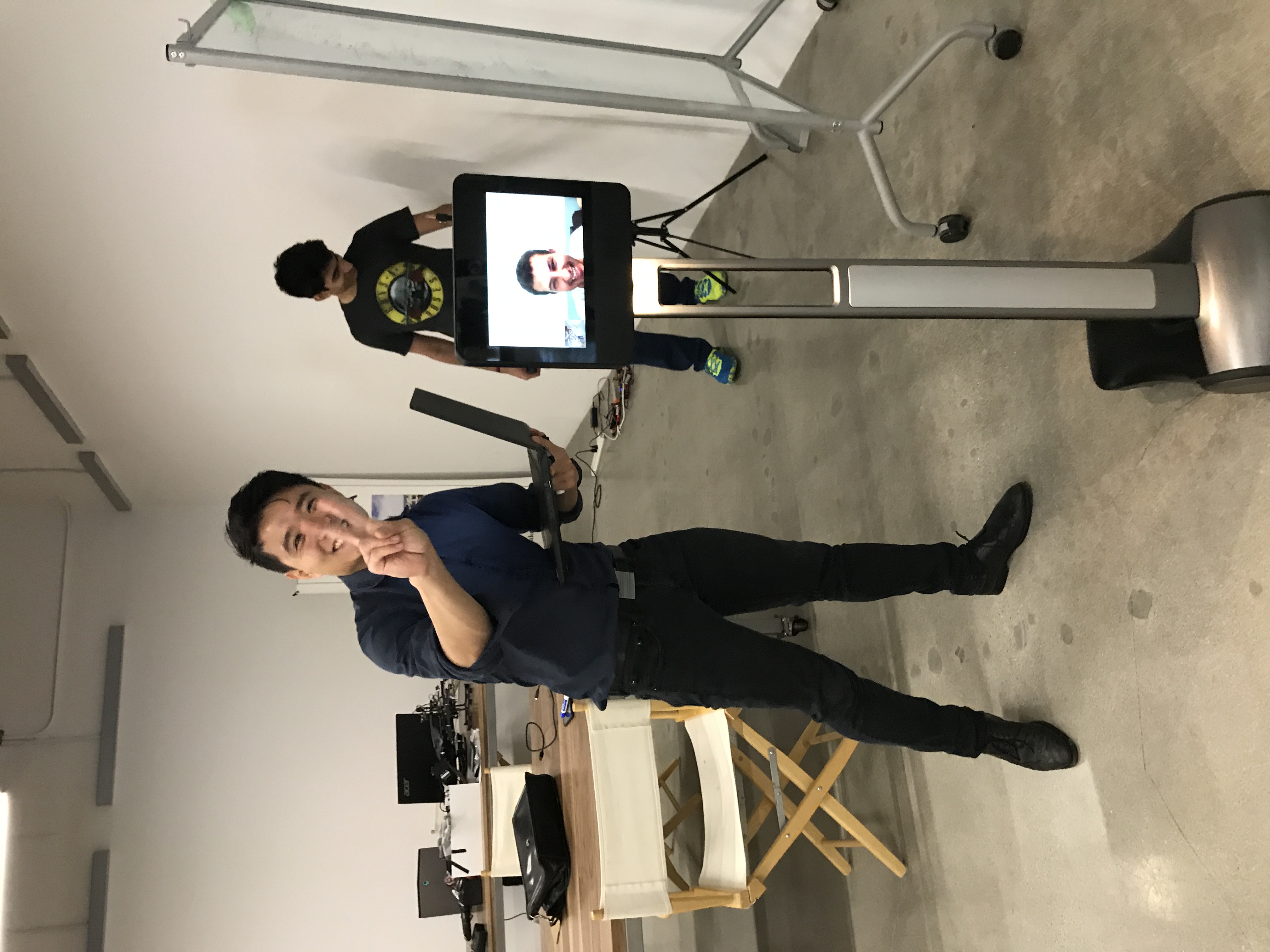 Person demonstrating a telepresence robot inside a startup workspace.