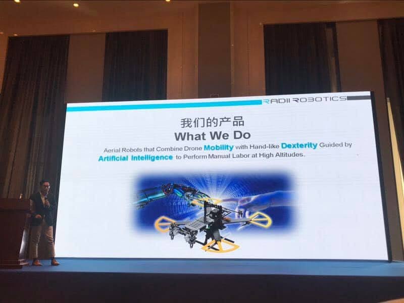 Radii Robotics presentation on a large stage with a robotics product displayed on screen.