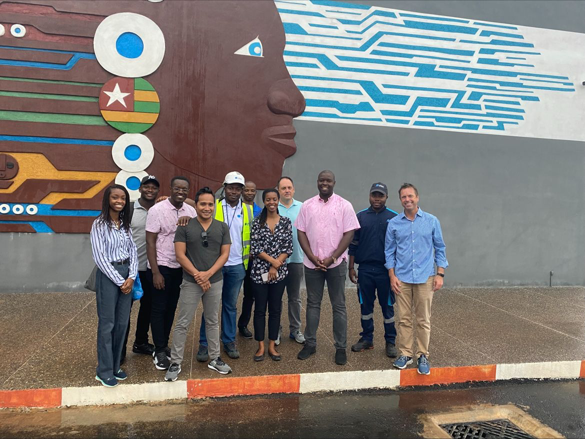 Development team standing together in front of a large public mural.