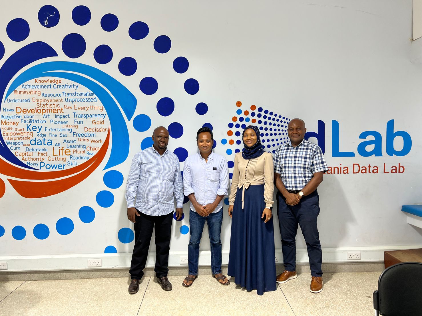 Four people standing together at the Tanzania Data Lab.