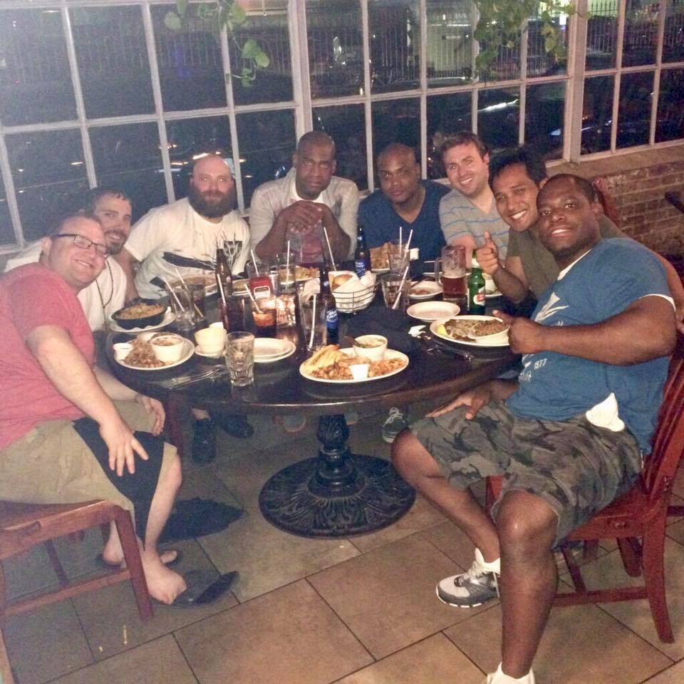 A group of friends gathered around a restaurant table.