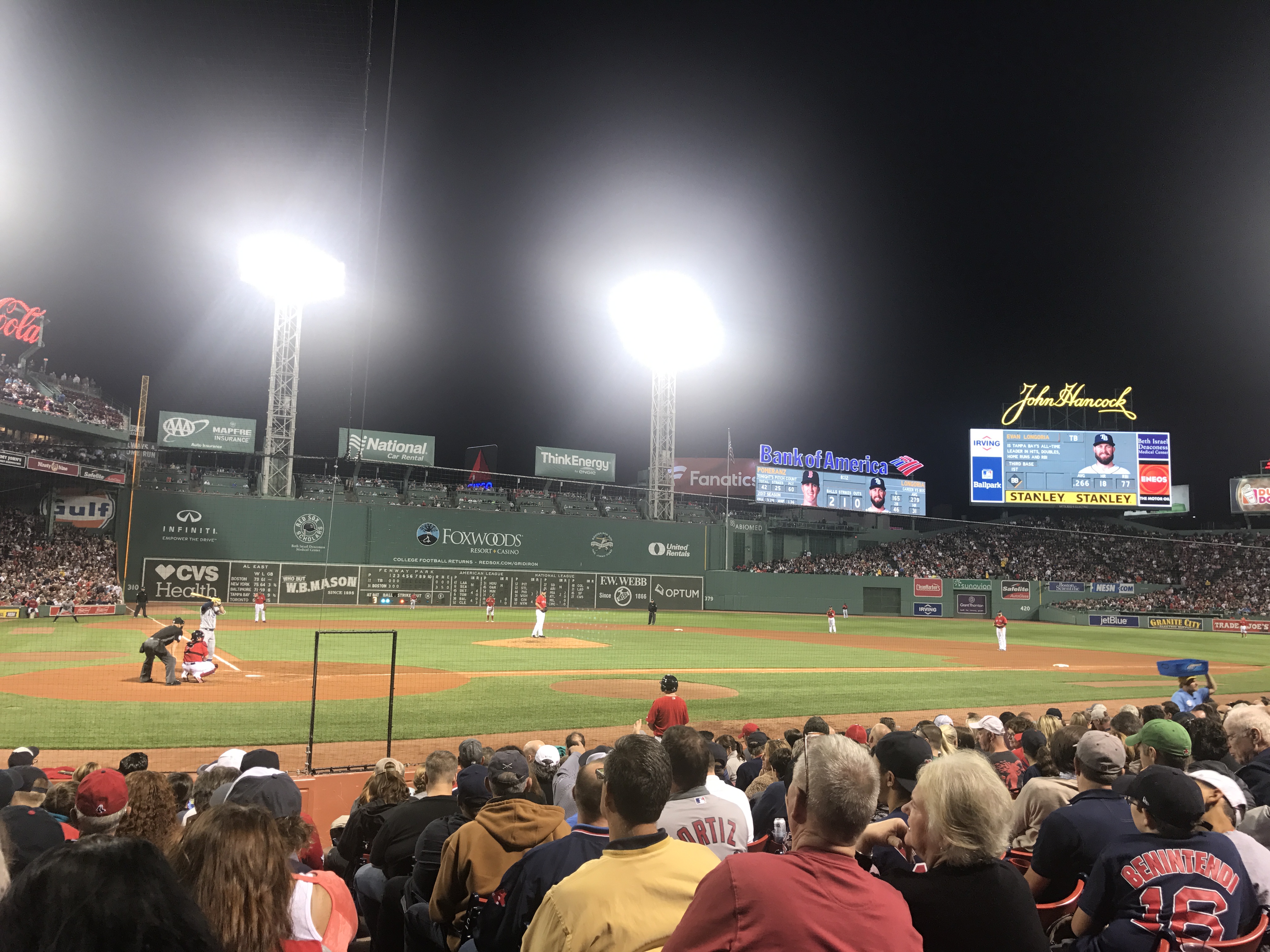 Nighttime view of a baseball game from the stands.