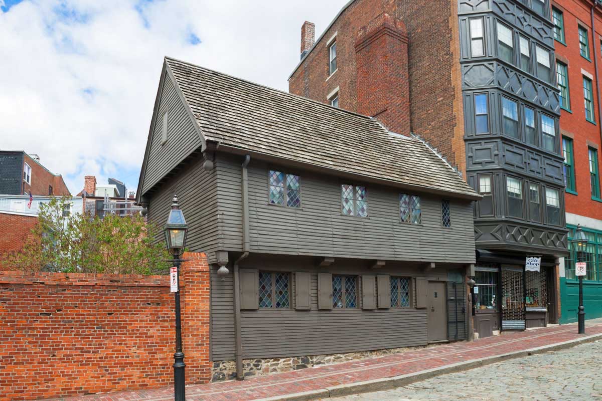 Historic wood-sided building on a brick-lined New England street.