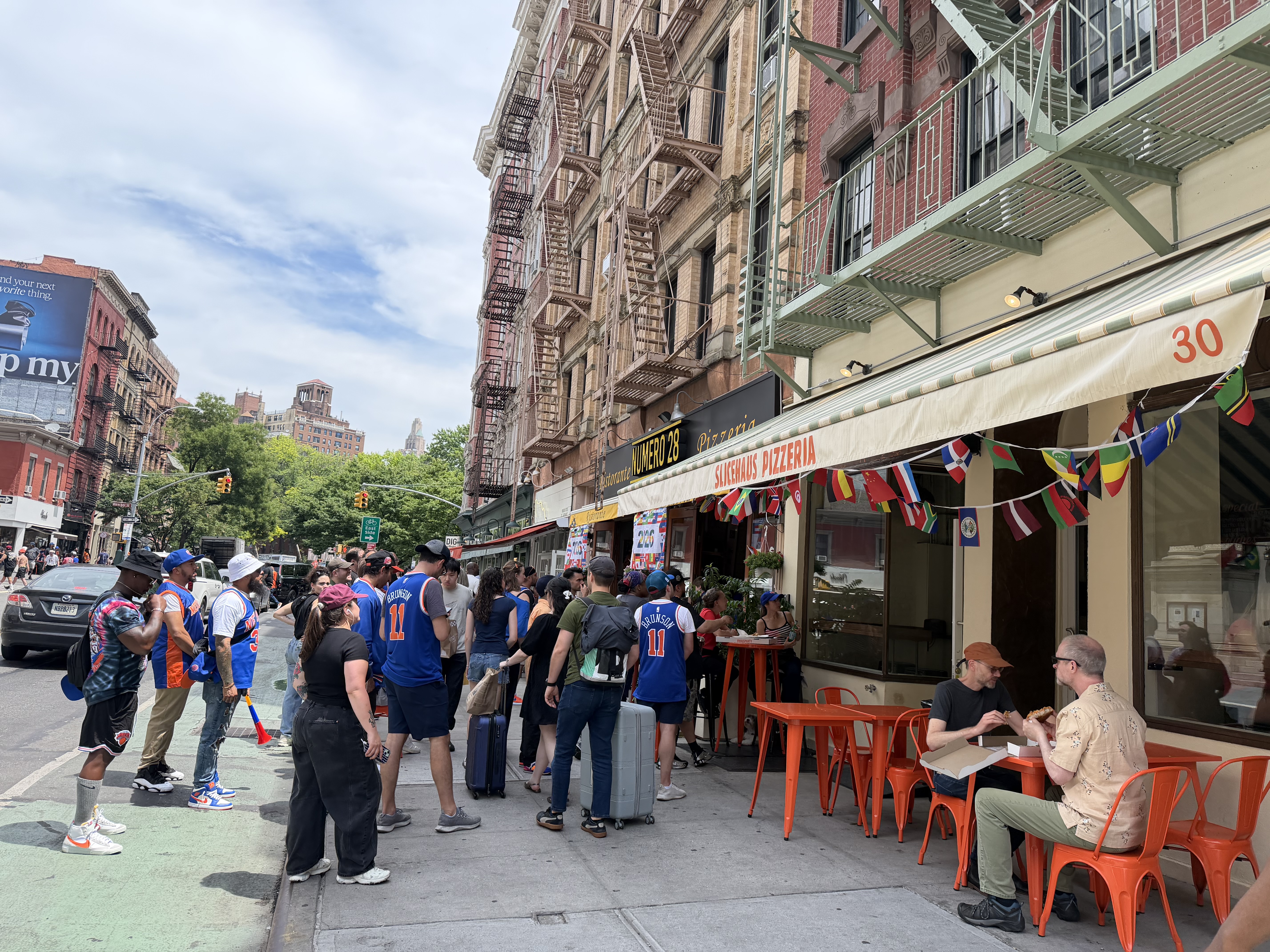 Knicks fans gathered outside restaurants on a New York City street.