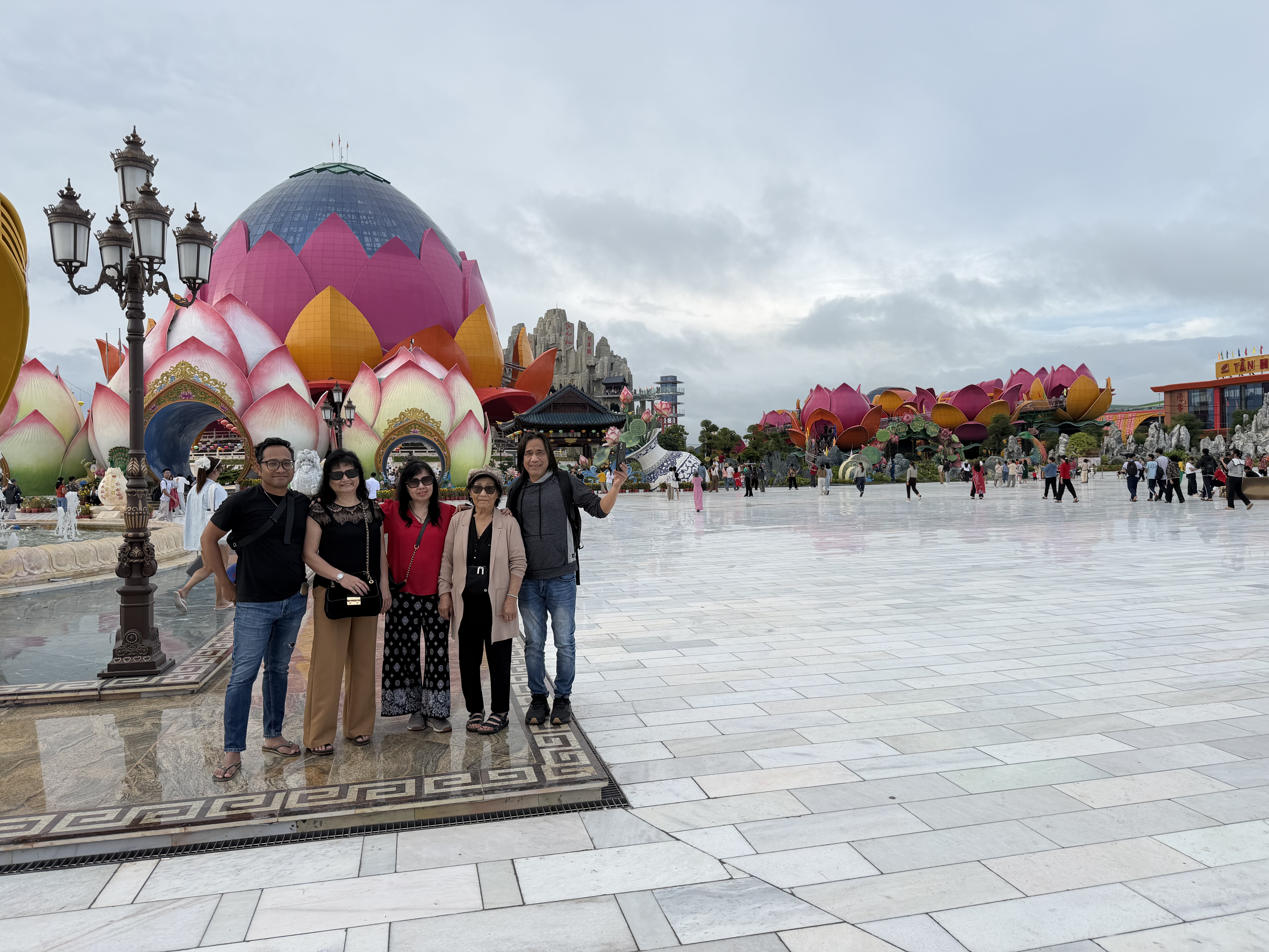 Family standing together in front of colorful lotus-shaped buildings.