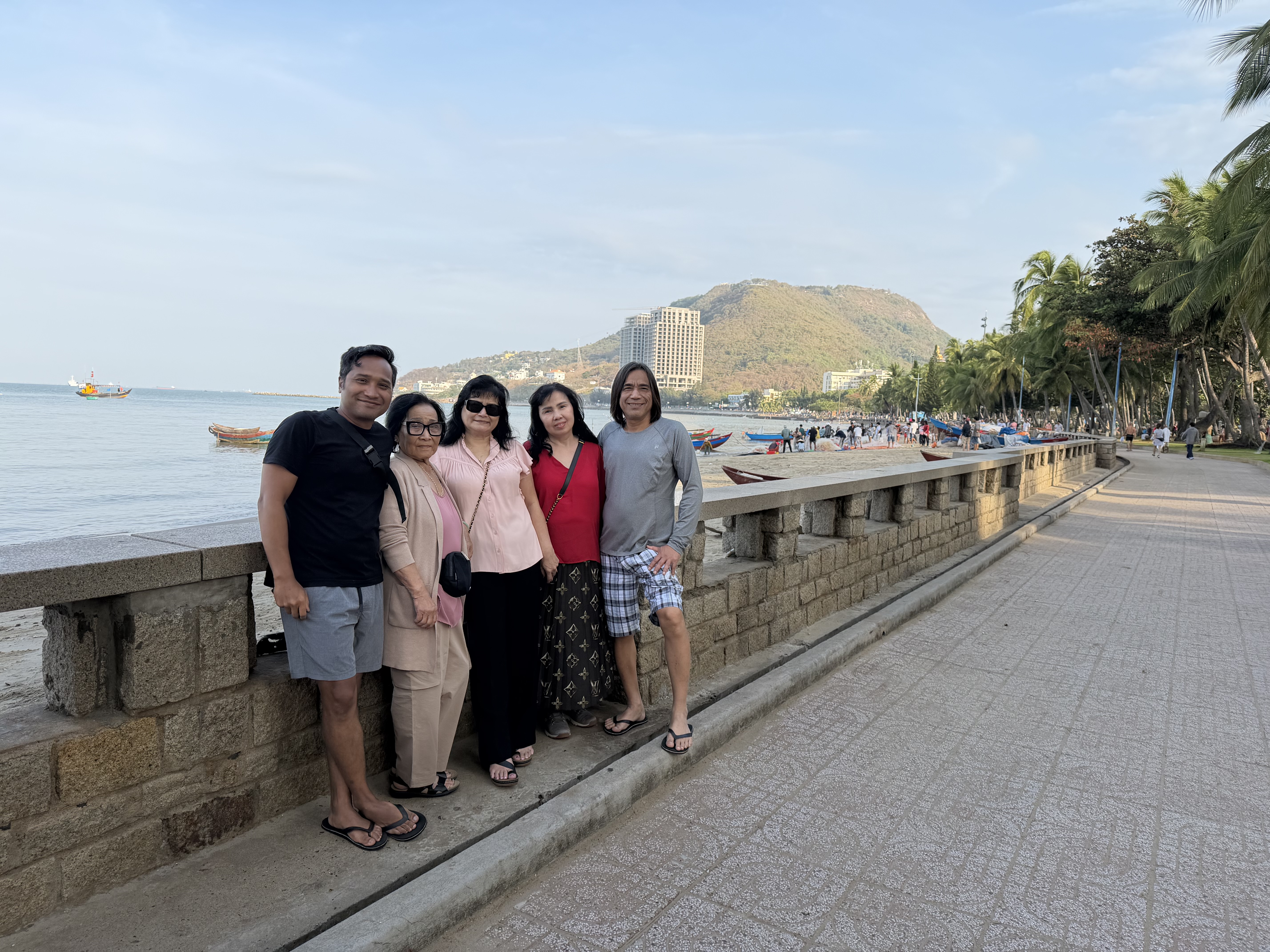 Family standing together along a waterfront promenade in Vietnam.