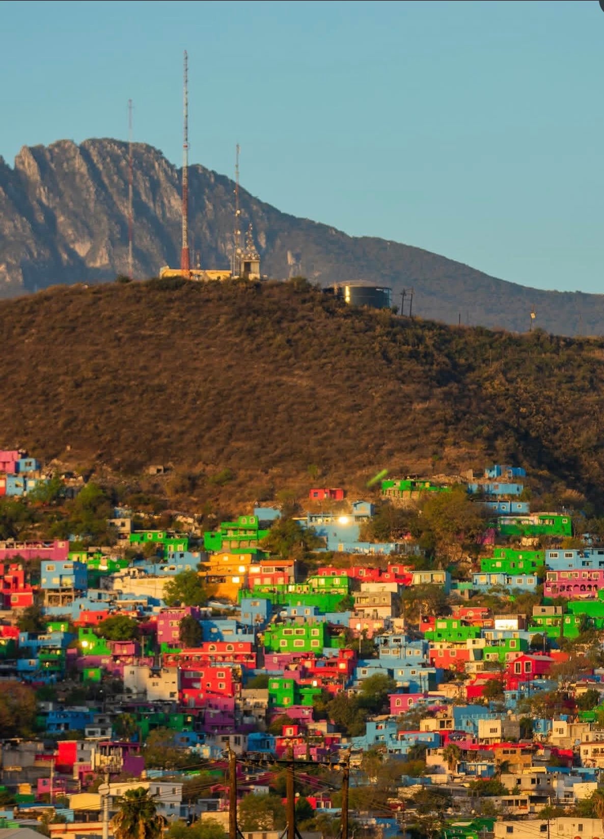 Colorful hillside neighborhood beneath mountains.